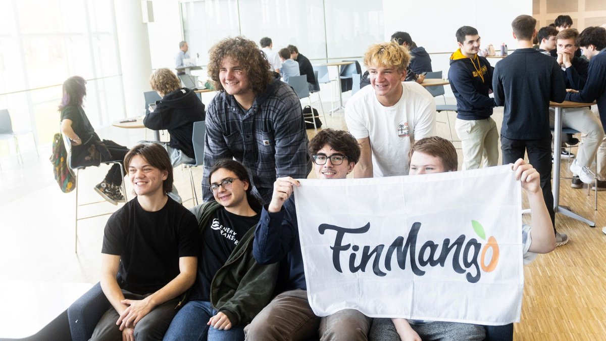 Students holding the FinMango flag at a program session